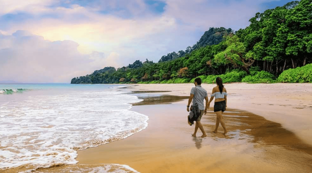 A couple strolling on a Andaman beach, enjoying the serene beauty of the coastline and the soothing sound of the waves.