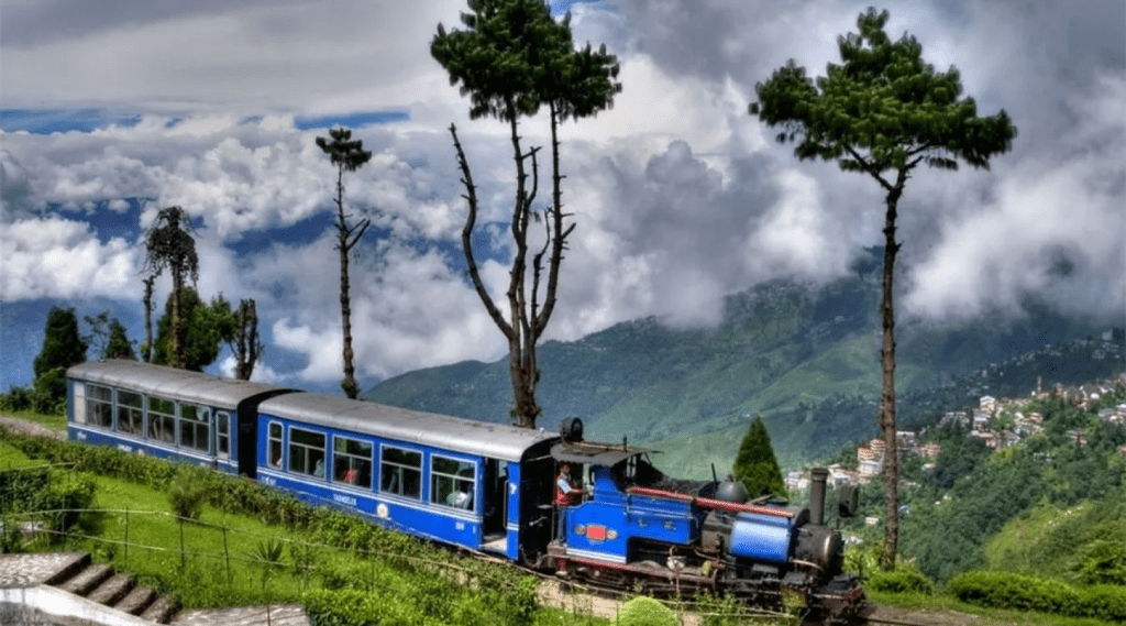 A blue train winds through misty mountains on a cloudy day, showcasing the beauty of nature and transportation.