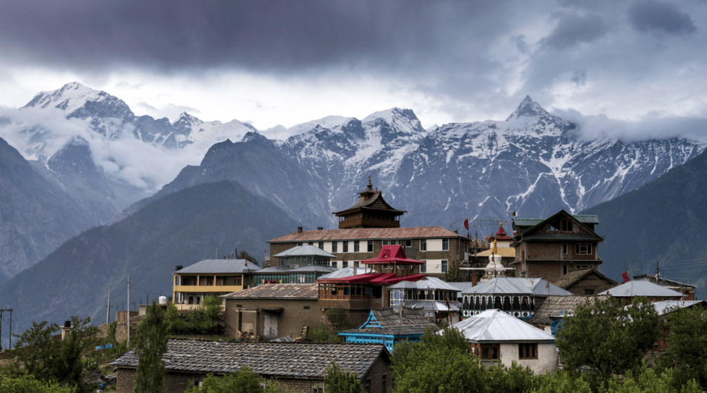 A picturesque mountain village with snow-capped peaks in the backdrop, creating a serene and breathtaking scene.