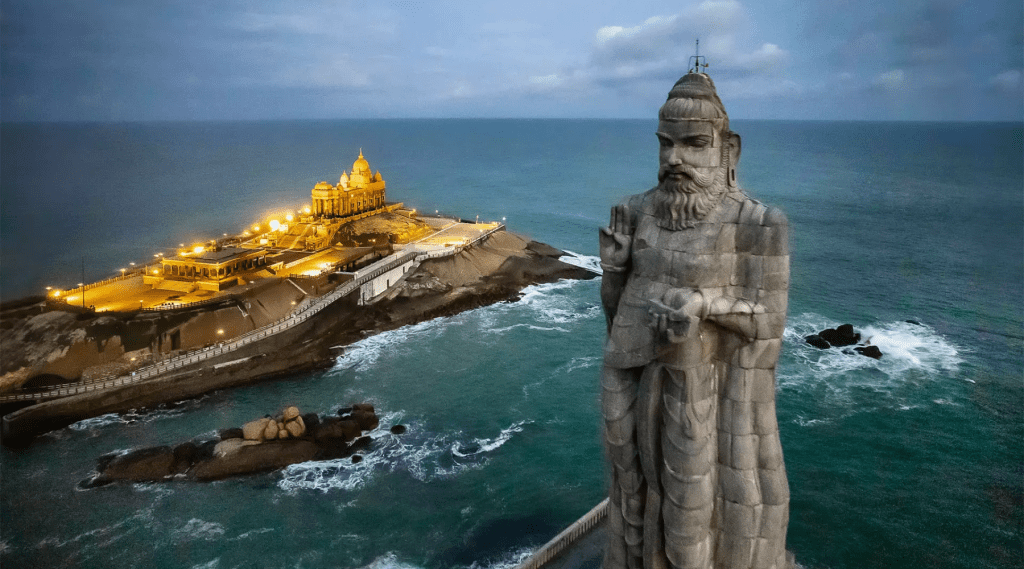 A statue of Thiruvalluvar stands atop a rock near the ocean, symbolizing strength and divinity.
