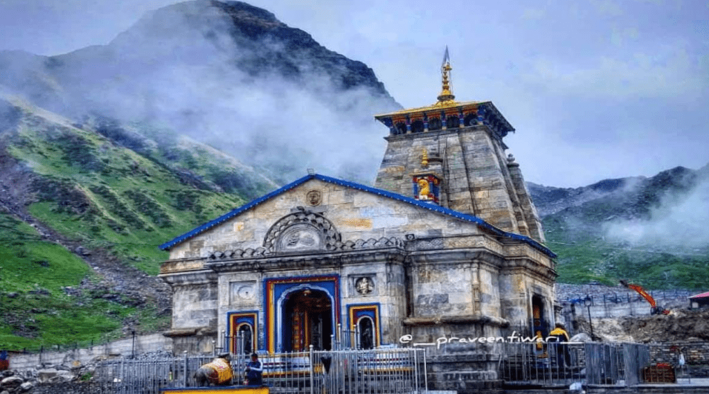 Temple nestled amidst majestic mountains and ethereal clouds.