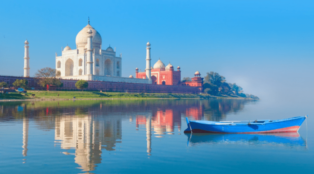 A picturesque view of a boat floating beside the majestic Taj Mahal.
