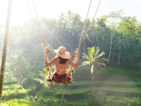Woman on a jungle swing above the Tegalalang rice terraces in Bali