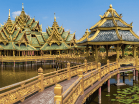 Golden pagodas are situated in the middle of a calm lake, enhancing the landscape with their striking presence.