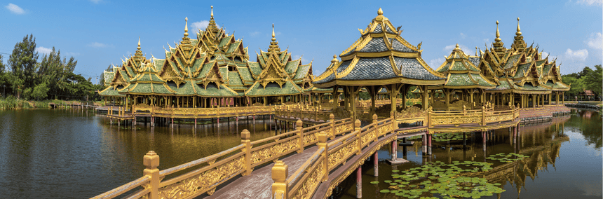 Golden pagodas are situated in the middle of a calm lake, enhancing the landscape with their striking presence.