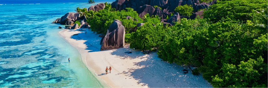 Aerial view of a Seychelles island showcasing sandy beaches and rocky formations surrounded by turquoise waters.