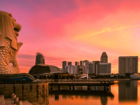 Singapore skyline illuminated by a vibrant sunset, showcasing modern architecture against a colorful sky.