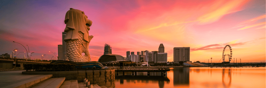 Singapore skyline illuminated by a vibrant sunset, showcasing modern architecture against a colorful sky.