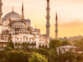 The Blue Mosque in Istanbul, Turkey, showcasing its iconic domes and minarets against a clear blue sky.