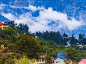 Colorful houses nestled in the mountains beside a serene lake, showcasing a picturesque landscape.