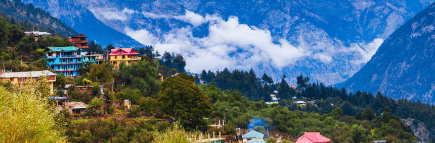 Colorful houses nestled in the mountains beside a serene lake, showcasing a picturesque landscape.