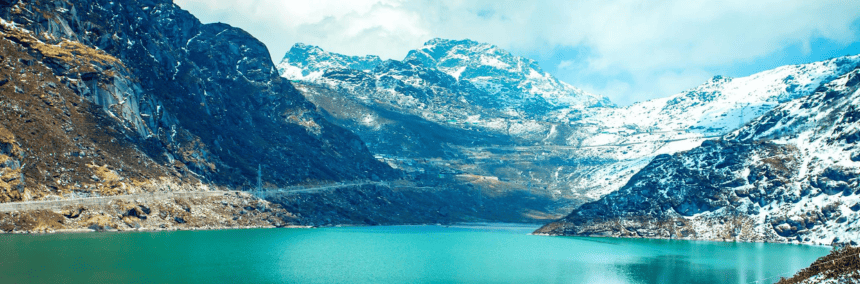 A serene lake nestled among majestic mountains, with a blanket of snow covering the peaks.